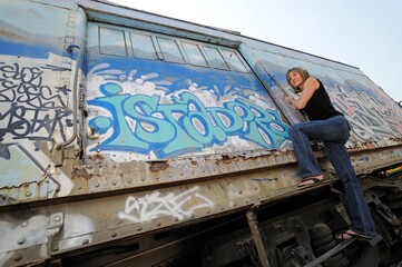 Woman climbs old railroad boxcar, Santa Fe, NM, USA