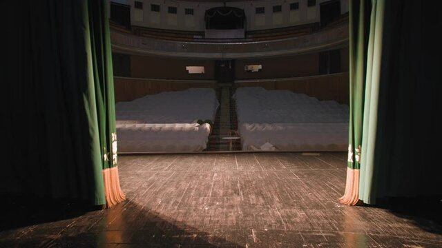 curtain opens, empty theater stage with spotlights and velvet curtains, blank hall during coronavirus pandemic