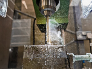 Smoke and drops from coolant liquid on a drill bit