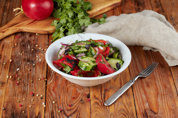 Salad of tomatoes, cucumbers, peppers, onions and greens dressed