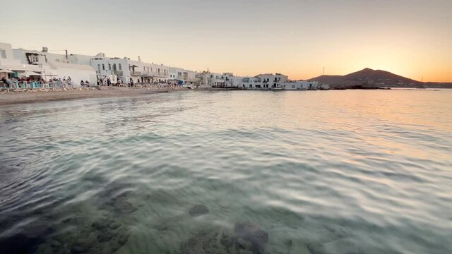 beautiful sunset on the clear sea, promenade with restaurants, Greek cycladic island Paros Naoussa Greece