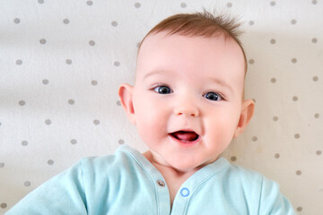 Fototapeta premium Teeth are teething at the infant baby, smiling face close-up. Portrait of a happy child aged six months
