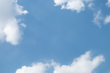 White Clouds on the bright sunny blue sky. Nature background.