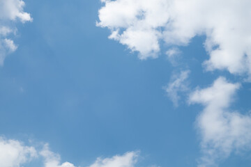 White Clouds on the bright sunny blue sky. Nature background.