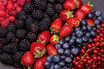 Different berry fruits background. Strawberry, blueberry, raspberry, red currant and blackberry mix.