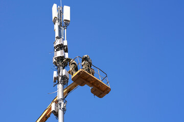 Modification of cellular communication. Service. Engineers install additional slots on the tower.