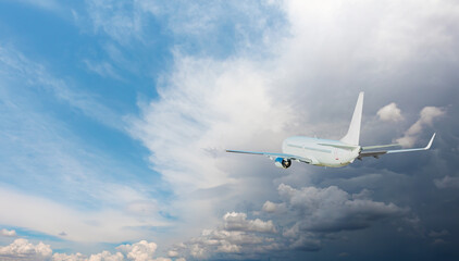 Fototapeta na wymiar White passenger airplane flying in the sky amazing clouds in the background - Travel by air transport