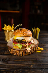 Hamburger. Sandwich with chicken burger, tomatoes, pickled cucumber and fried egg. Fresh tasty chicken burger on wooden table. - obrazy, fototapety, plakaty