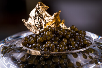 An open glass jar of sturgeon caviar. Top view.