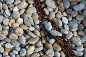 Rusty chain on pebble beach