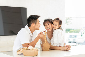 HERMOSA FAMILIA ORIENTAL DISFRUTANDO DE UNA DELICIOSA COMIDA	