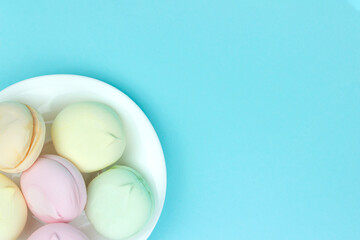 Different mini green, pink and orange puffy marshmallows looks like macaroons. A lot of handmade marshmallow.