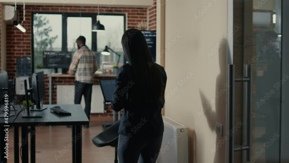 Poster programer holding laptop with coding interface entering software development agency office sitting d