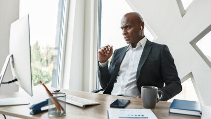 Focused black male businessman watch on computer