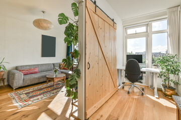 Barn door separating living room from workroom in cozy apartment