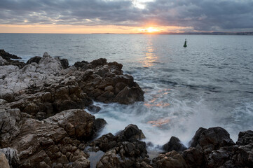Paysage marin du rivage méditerranéen au Cap de Nice en hiver avec des vagues et des rochers au coucher du soleil