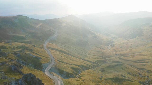Amazing mountain road. 4K aerial view of Transalpina motorway from Romania during a beautiful summer sunrise. Scenery landscape.