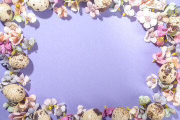 Spring Easter background, with small Easter eggs decoration, spring blossom flowers on violet very peri color background flatlay frame 