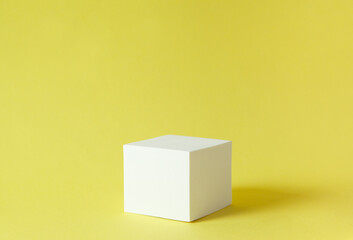 white cube on yellow background