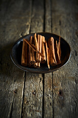Ceylon cinnamon sticks on black ceramic plate - 479603209