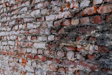 Old wheathered red bricks of an old  facade wall with vanishing point persepective. Background pattern made by masonry craftsmen building the house in 19th-20th century in Iserlohn Germany.