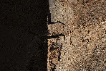 a corner of an old wall with one side in shadow