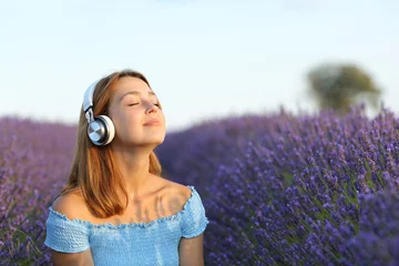 Tuinposter Female breathing listening to music in a lavender field © PheelingsMedia