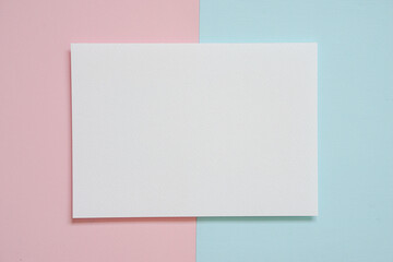 horizontal blank white A4 paper on pink and blue paper pastel. flat lay, copy space.