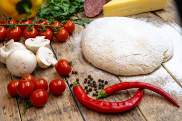ingredients for making pizza, before baking, on a wooden table, top view, step-by-step recipe