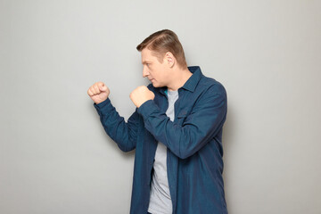 Portrait of mature man holding clenched fists in front of him