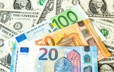 Fototapeta na wymiar Various banknotes of Euro currency on the dollars background