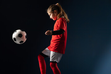 Little girl kicks soccer ball