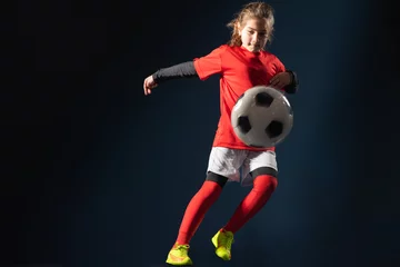 Zelfklevend Fotobehang Little girl kicks soccer ball © Dusan Kostic