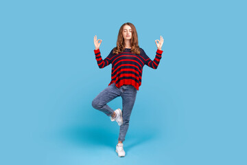 Full length portrait of peaceful woman wearing casual style sweater with mudra gesture hands up,...