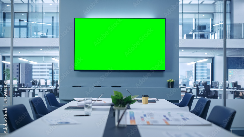 Aufkleber Modern Empty Meeting Room with Big Conference Table with Various Documents and Laptops on it, on the Wall Big TV with Green Chroma Key Screen. Contemporary Minimalistic Designed Workplace.