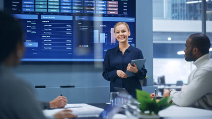 Diverse Modern Office: Portrait of Successful Caucasian Businesswoman Uses TV Screen with Big Data,...