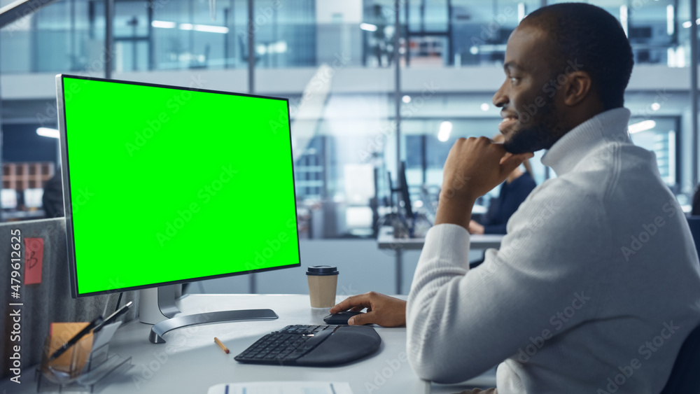 Leinwandbilder Diverse Modern Office: Handsome Black IT Technician Using Desktop Computer with Green Chroma Key Screen. Engineer Administrator Work on e-Commerce Development, Project Marketing, Big Data Analysis