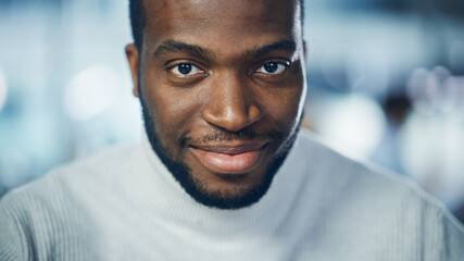 Close-up Portrait of Handsome Black Man with Deep Brown Eyes, Trimmed Beard, Wearing Stylish...