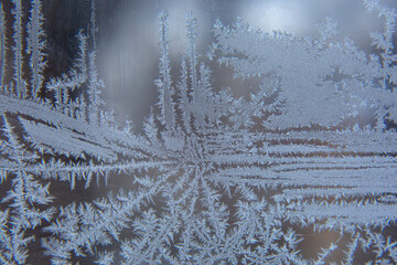 frosty patterns on the window glass closeup. natural textures and backgrounds. ice patterns on...