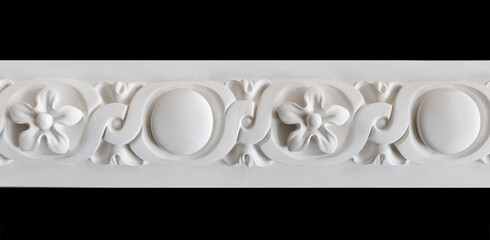 A fragment of a white plaster ceiling molding with an ornament.