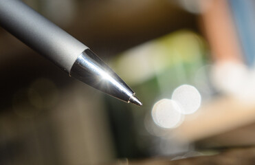 Ballpoint silver pen close-up on a blurred background. Concept - sign documents