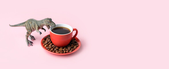 dinosaur toy and Cup of coffee with coffe beans on pink background. minimal creative concept. banner. copy space. 