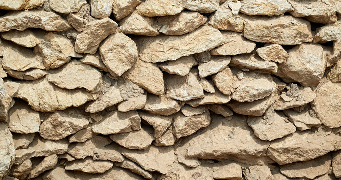 Old beige stone wall background texture