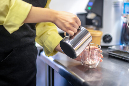 Close up picture of a womans hands pouring cocoa into the glass