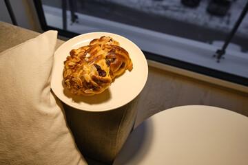 Woman's Hand Holding Delicious Swedish Buns, Kanelbullar. Baking close-up. A sweet snack. Traditional Swedish pastries