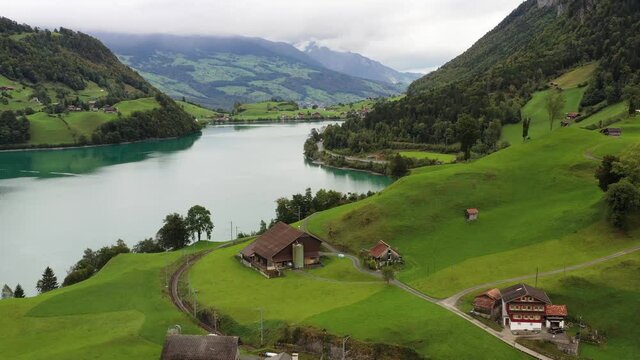 A village Lungern in Switzerland. Field  and houses. A sunny day and a mountain valley. Landscape frome drone.
