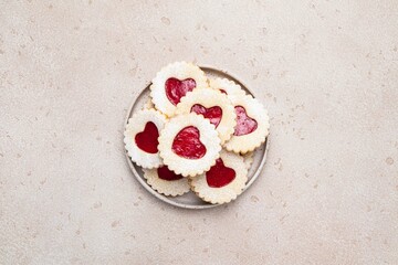 Linzer cookies in shape of heart with jam on light background. Mother's day, Women's day, Valentine's day. Homemade present. Copy space, top view.