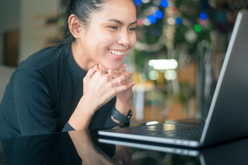 A young happy woman is surprising while using computer laptop in cafe. people and technology concept...