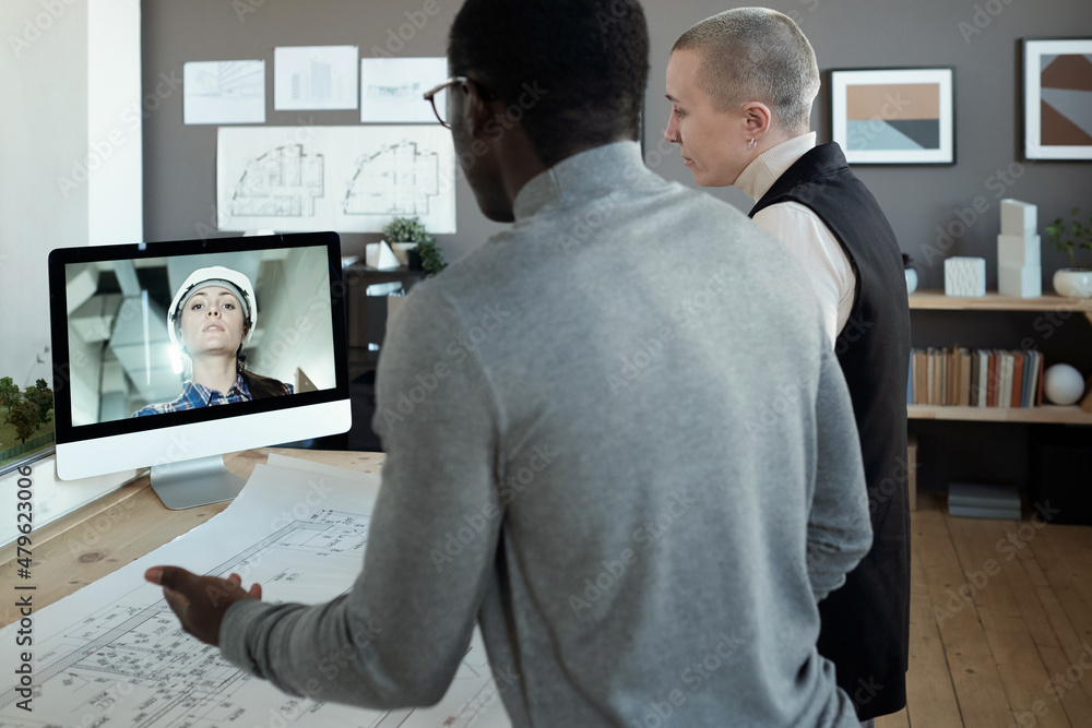 Poster two contemporary architects communicating to female builder on computer screen while standing by tab