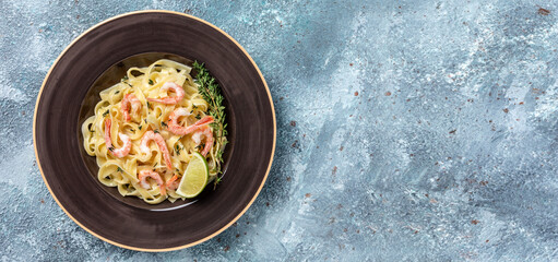 Pasta tagliatelle with shrimps in creamy sauce and thyme, fettuccine pasta. Italian food, top view